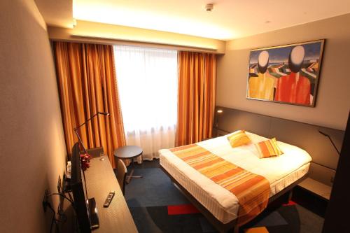 a hotel room with a bed and a window at Mercure Kyiv Congress in Kyiv