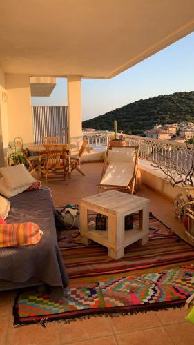 - un balcon avec un canapé et une table dans l'établissement Deux pièces , grande terrasse vue mer corse, à LʼÎle-Rousse