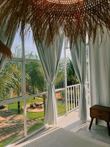 a bedroom with a large window with blue curtains at Chon's Dock Homestay & Apartment For Lease in Phan Thiet