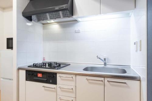 a kitchen with a sink and a stove at Daffitto Tennozu in Tokyo