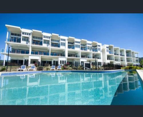 a large apartment building with a large swimming pool at Island Romance or Family & Pool in Nelly Bay