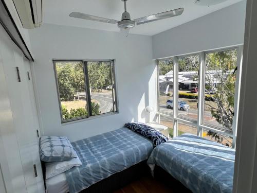 a bedroom with two beds and a window at Island Romance or Family & Pool in Nelly Bay