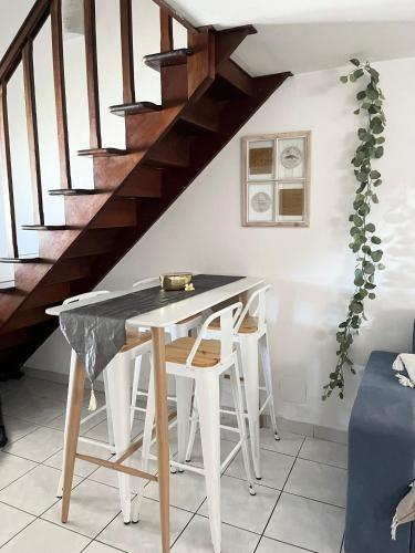a table and chairs in a room with stairs at Ti Lamp Ti Lamp: Cocon de Sérénité Près de la Mer in Saint-Paul