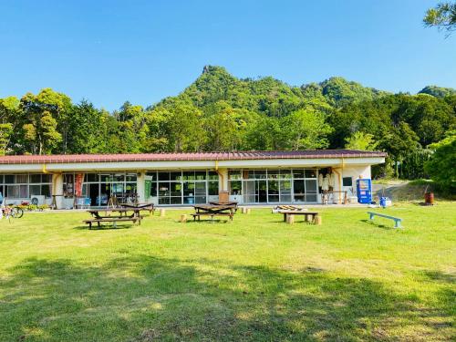 a building with picnic tables in front of it at Heguri Hub in Minamiboso