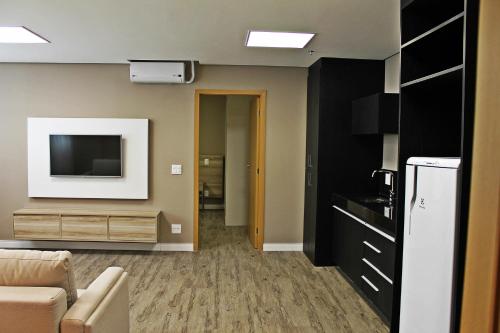 a living room with a couch and a tv at Ville Celestine Hotel in Belo Horizonte