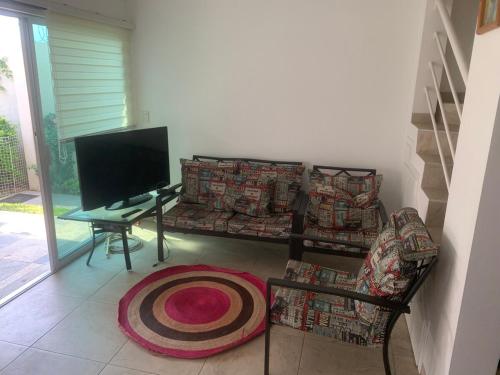 a living room with a tv and a couch and a table at Sweet and Family home!! in Xochitepec