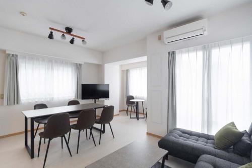 a living room with a couch and a table and chairs at Daffitto Tennozu in Tokyo