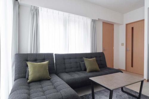 a living room with a couch and a table at Daffitto Tennozu in Tokyo