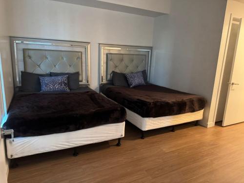 two beds sitting in a room with wood floors at Stylish Urban Escape in Downtown Los Angeles in Los Angeles