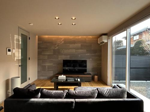 a living room with a couch and a flat screen tv at 63 Fuji Petel TROIS -トロワ- in Fujikawaguchiko