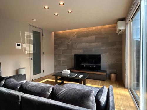 a living room with a couch and a flat screen tv at 63 Fuji Petel TROIS -トロワ- in Fujikawaguchiko