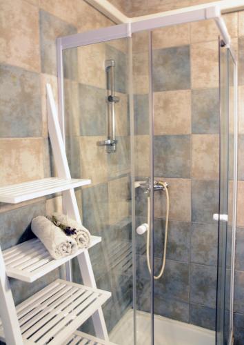 a shower with a glass door and a bench in a bathroom at Apartments Marjana in Portorož