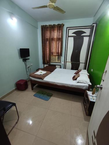 a bedroom with a bed and a green wall at Hotel Viraat Inn in Gaya