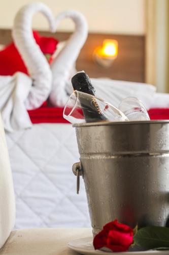 a bucket on a table next to a bed with swans at Atlântico Hotel in Santos