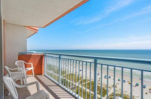 a balcony with two chairs and a view of the beach at Oceanfront Ocean Pearl in Myrtle Beach in Myrtle Beach