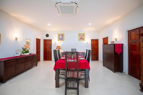 a dining room with a red table and chairs at Sriwaree Pool Villa Khao Lak - 8 meters pool - 3 bedroom - 2 bath in Khao Lak