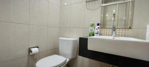 a bathroom with a toilet and a sink at Tranquil 1BR - Kuningan Place in Jakarta