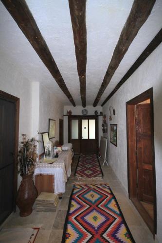 a room with two beds and a ceiling with a rug at Beymelek Tas Evler in Demre