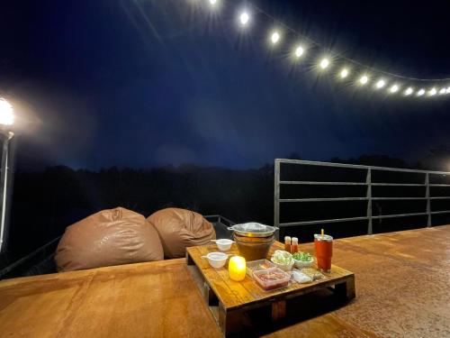 a balcony with a table with food on it at River Hill Khaokho in Khao Kho