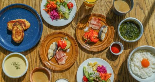 a wooden table with plates of food on it at SETOUCHI KEIRIN HOTEL 10 by Onko Chishin in Tamano