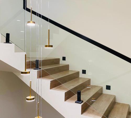 a staircase with wooden steps and glass railing at Fuxian Lake Qishe B&B in Chengjiang