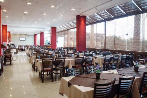 uma grande sala de jantar com mesas e cadeiras em Hotel Estação 101 - Itajaí em Itajaí