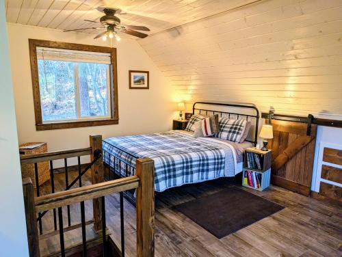 a bedroom with a bed and a ceiling fan at 4 Mile Creek Cabin (Creekside) in Nelson