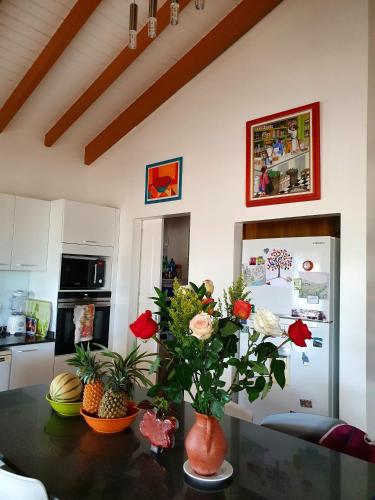 a kitchen with a table with a vase of flowers on it at Chambre créole et sa salle de bain chez Michelle in La Désirade