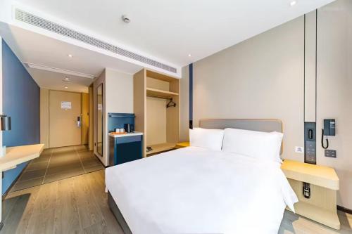 a bedroom with a large white bed and a hallway at Holiday Inn Express Hangzhou Qianjiang CenturyCity by IHG in Hangzhou