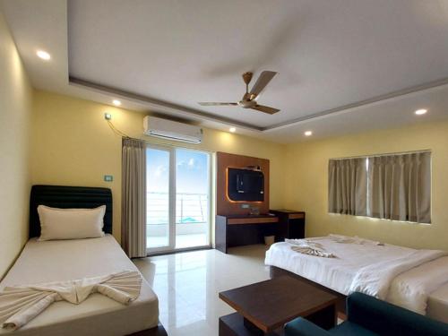 a hotel room with two beds and a tv at Sonargaon Beach Resort in Mandarmoni