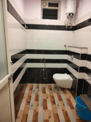 a bathroom with a white toilet and black and white stripes at Sonargaon Beach Resort in Mandarmoni