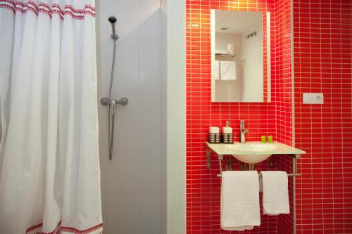 a red tiled bathroom with a shower and a sink at Apartamentos Campuebla in Montanejos