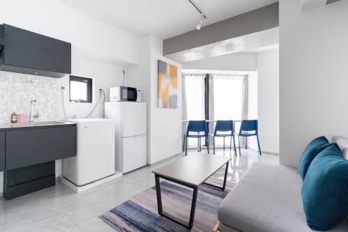 een keuken en woonkamer met een bank en een tafel bij Shinsen Hombe BLD in Tokyo
