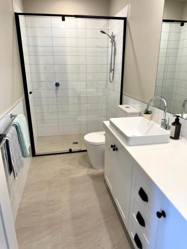 a bathroom with a shower and a toilet and a sink at Haven on Hunter Lux Townhouse in Mansfield