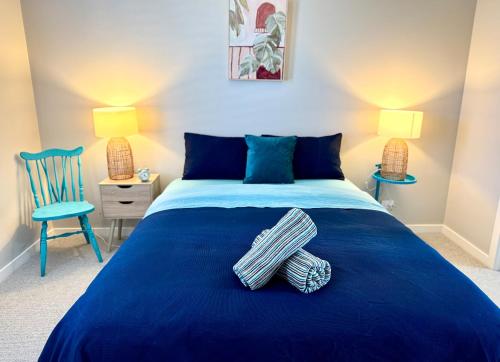a bedroom with a blue bed and a blue chair at Haven on Hunter Lux Townhouse in Mansfield