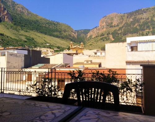 a chair sitting on a balcony with mountains in the background at Locanda Scirocco in Castellammare del Golfo