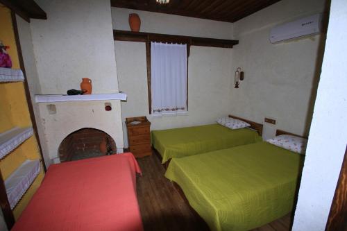 a small room with two beds and a fireplace at Beymelek Tas Evler in Demre