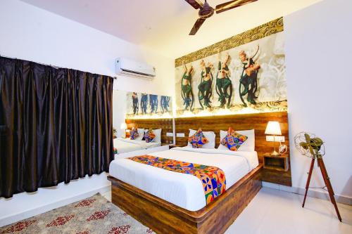 a bedroom with a bed and a painting on the wall at FabHotel DSR Hotel & Suites - Nr Hitech City Railway Station in Hyderabad