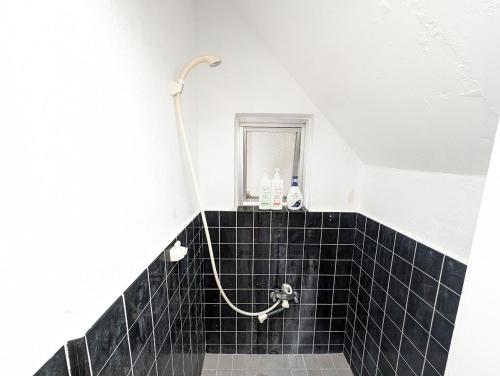 a bathroom with a black tiled floor and a shower at 那覇ワンツボ国際通りから徒歩圏内Okinawa Naha Main Street Walking in Naha