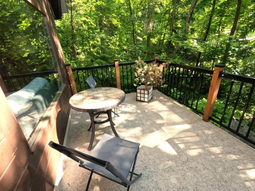a patio with a table and chairs on a balcony at 4 Mile Creek Cabin (Creekside) in Nelson