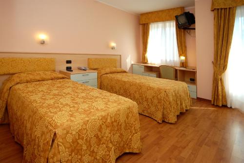 a hotel room with two beds and a television at Hotel La Bussola in Orta San Giulio