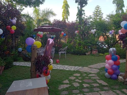 a garden with a bunch of balloons and an umbrella at Oxygen Homestay-A Blissful Retreat in Dehradun