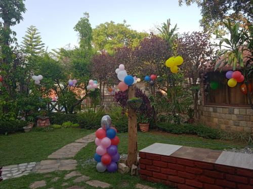 a statue in a garden with balloons in the yard at Oxygen Homestay-A Blissful Retreat in Dehradun