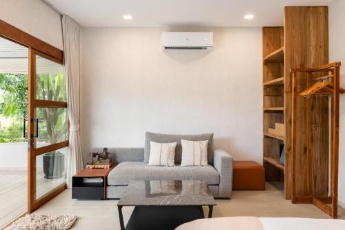 a living room with a couch and a table at Moorea Boutique Resort Samui in Ban Tai