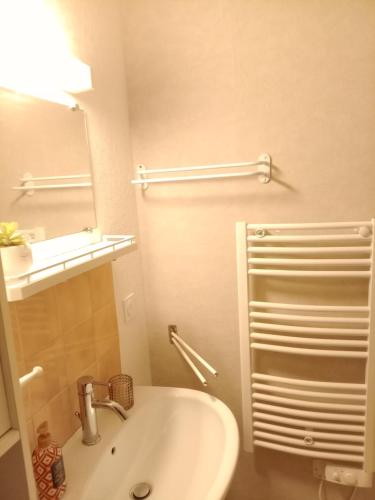une salle de bain blanche avec un lavabo et un miroir dans l'établissement Studio remblai, port, commerces, à Les Sables-dʼOlonne