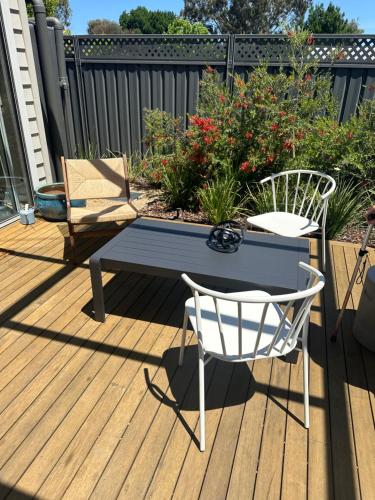 a bench and two chairs on a deck at Haven on Hunter Lux Townhouse in Mansfield