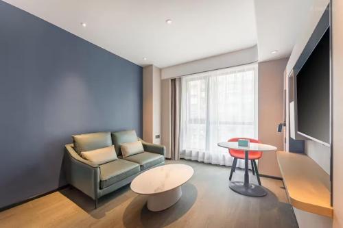 a living room with a couch and a table at Holiday Inn Express Hangzhou Qianjiang CenturyCity by IHG in Hangzhou
