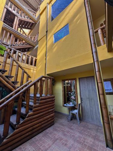 eine große Treppe in einem Haus mit einem Holzgeländer in der Unterkunft Hostal Bambumar in Cartagena de Indias