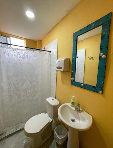 une salle de bains avec toilettes, lavabo et miroir dans l'établissement Hostal Bambumar, à Carthagène des Indes
