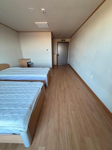a hospital room with two beds and a hallway at DMZ Hotel & Tour Guide in Paju